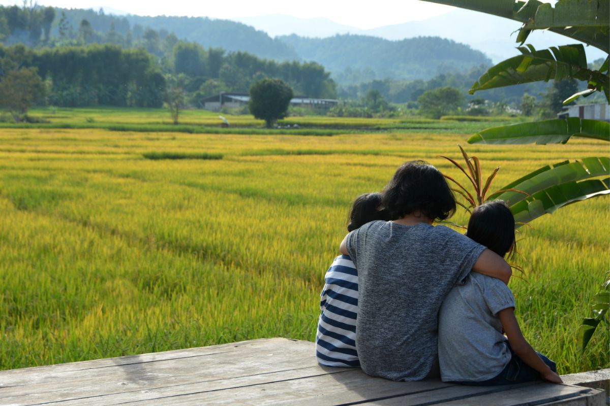 A family look out across the fields in Thailand as part of Care for Children’s project in the country